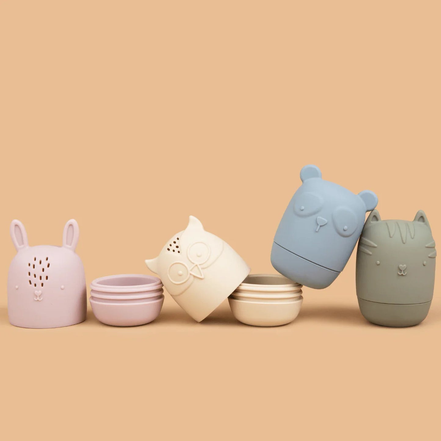 Five animal-shaped containers in pastel colors on a beige background