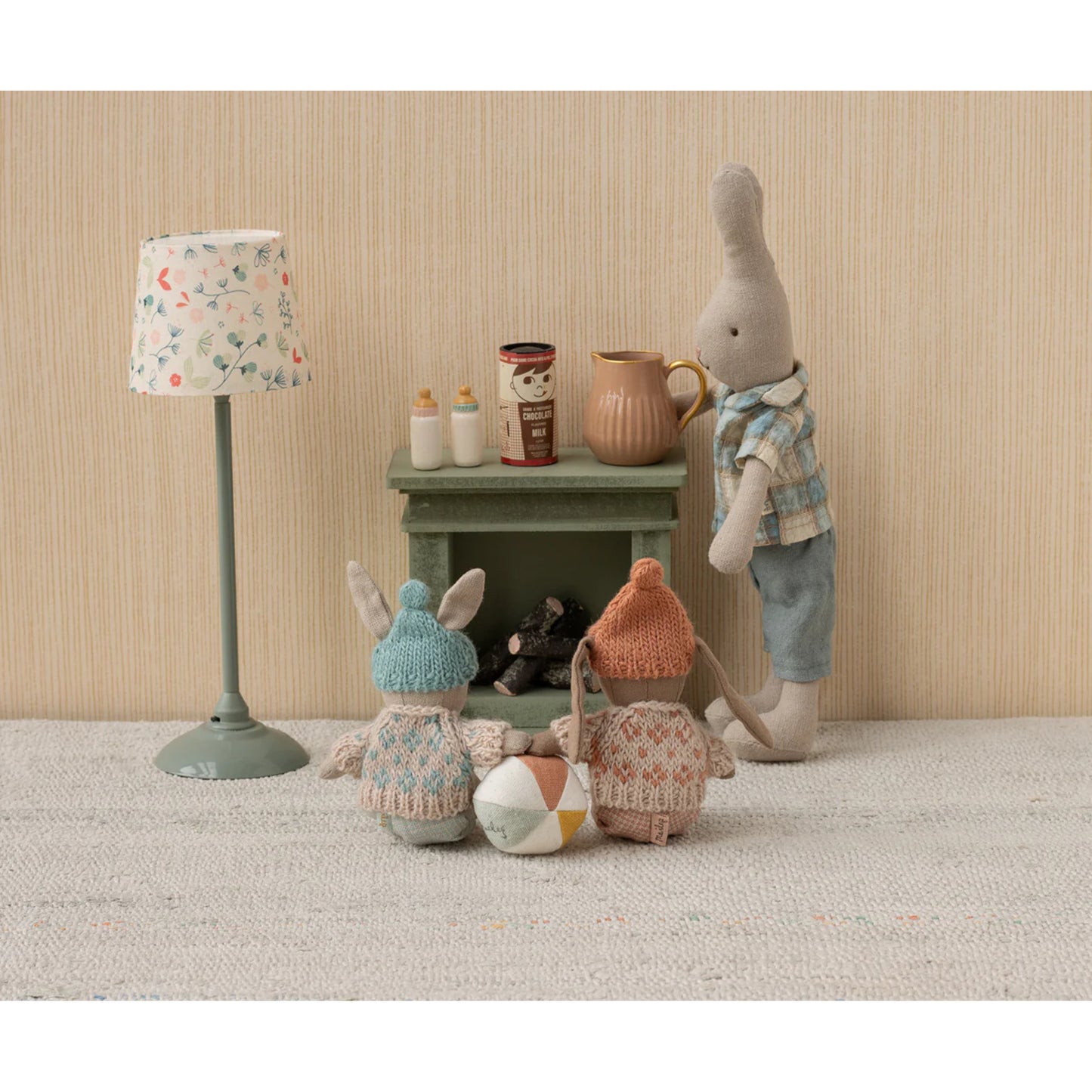 Toy figures of animals in a room with a lamp and small table.