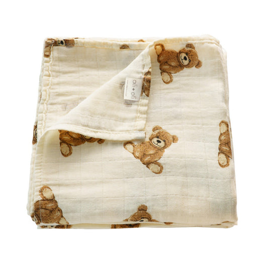 Folded baby blanket with teddy bear pattern on a white background