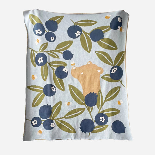 Baby blanket with bear and blueberry pattern on a light blue background