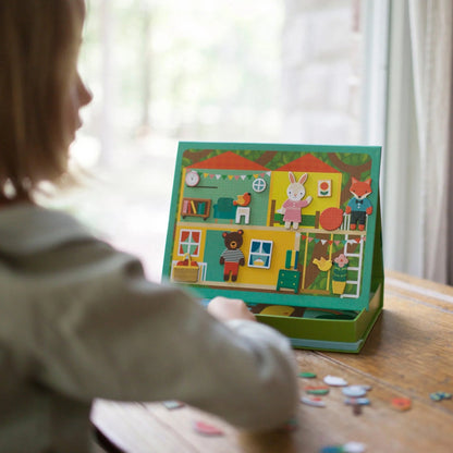 Child playing with a colorful board game on a wooden table.