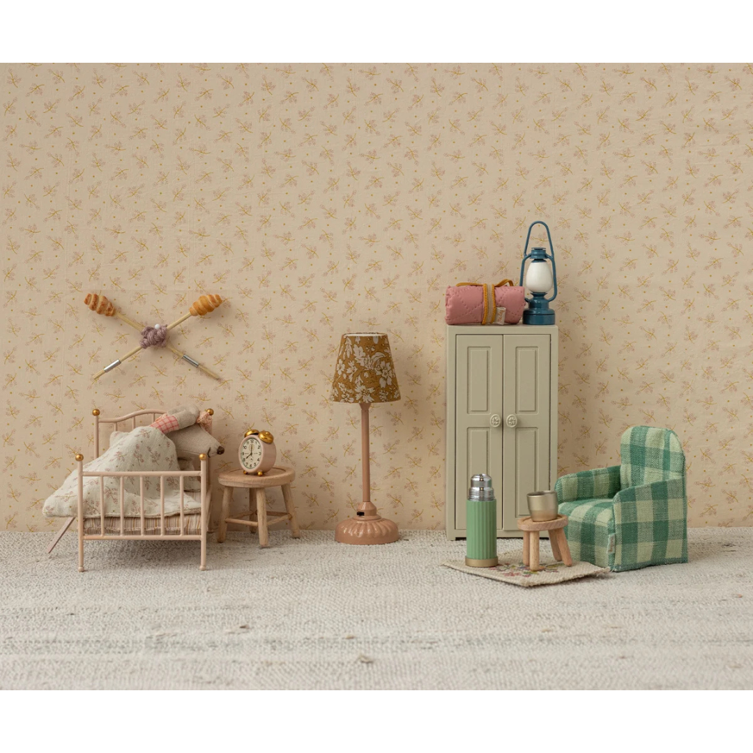 Miniature room setup with furniture and decor on a neutral background