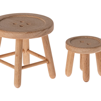 Two wooden stools with round seats on a white background