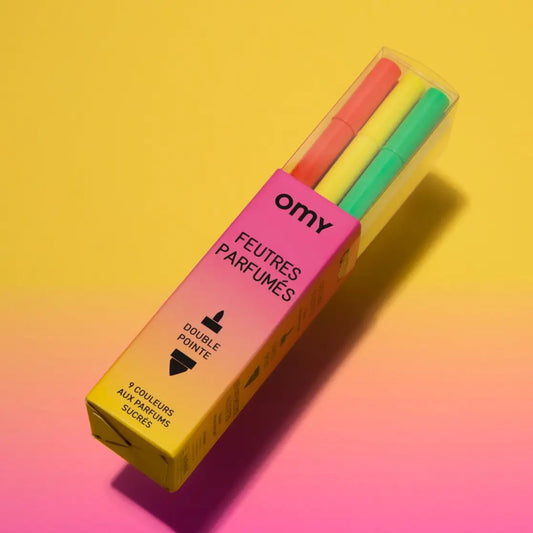 Pack of colorful perfume markers with 'omy' branding on a gradient yellow to pink background