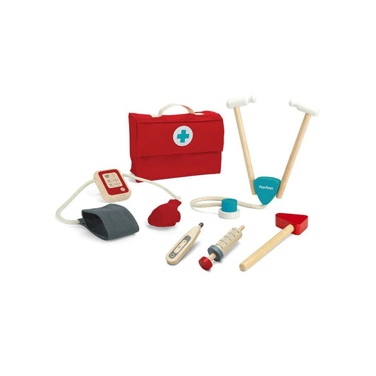 Set of toy medical tools and a red first aid kit on a white background