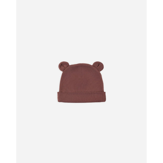 A dusty rose pink knit beanie hat with small bear ears on top, shown against a plain white background.