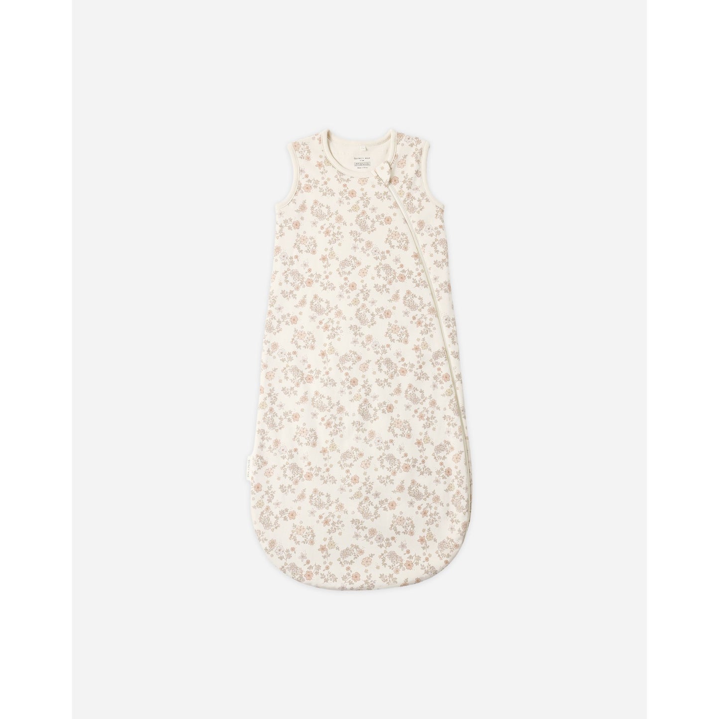 A sleeveless baby sleep sack with a delicate beige and cream floral pattern, shown flat against a light gray background.