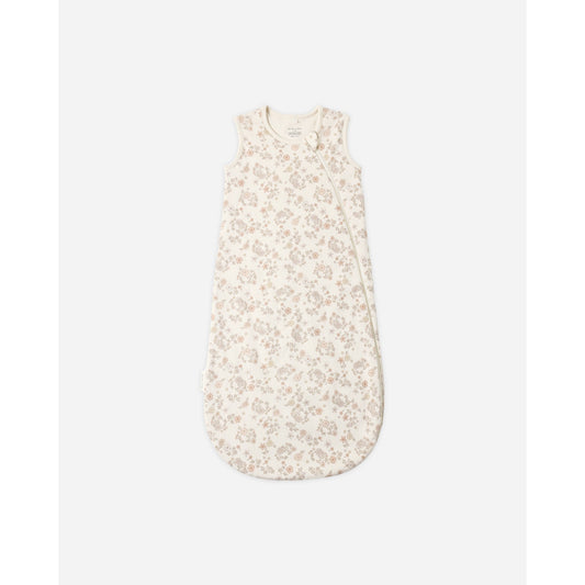 A sleeveless baby sleep sack with a delicate beige and cream floral pattern, shown flat against a light gray background.
