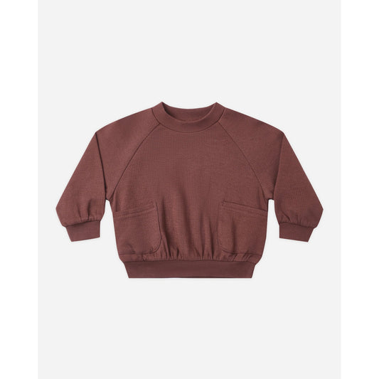 A dusty rose brown waffle-knit long-sleeve sweatshirt with front patch pockets, displayed flat against a light gray background.