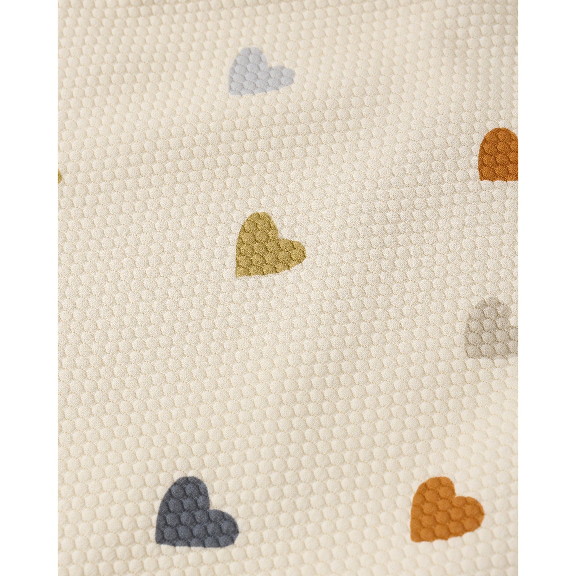 Textured fabric with colorful heart shapes on a beige background