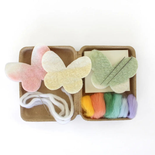 Butterfly-shaped felt items in a small cardboard box on a white background