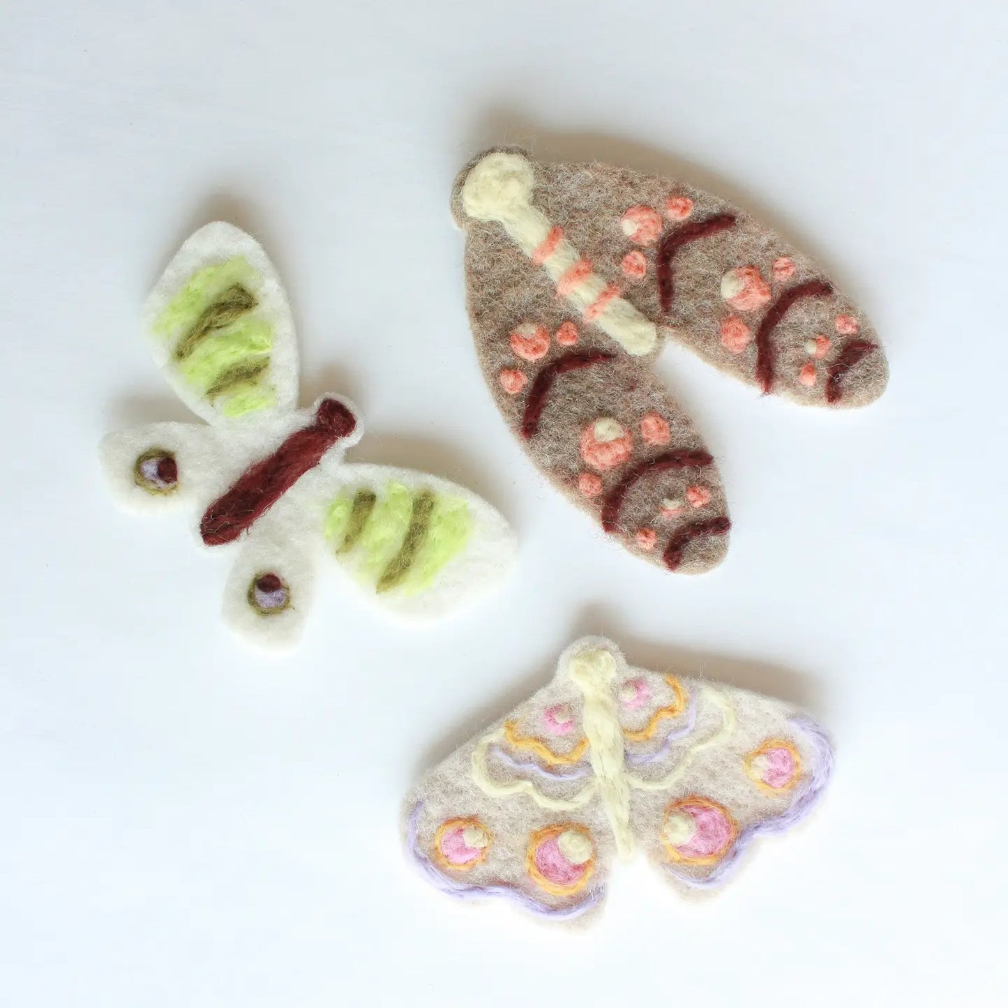 Four felt butterfly shapes on a white background