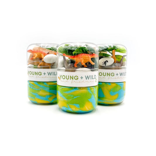 Three small jars with colorful marbled designs and toy dinosaurs on a white background, featuring the brand 'Young + Wild'.