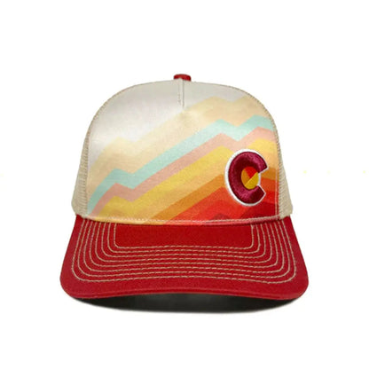 Colorful trucker hat with a mountain design and red brim on a white background