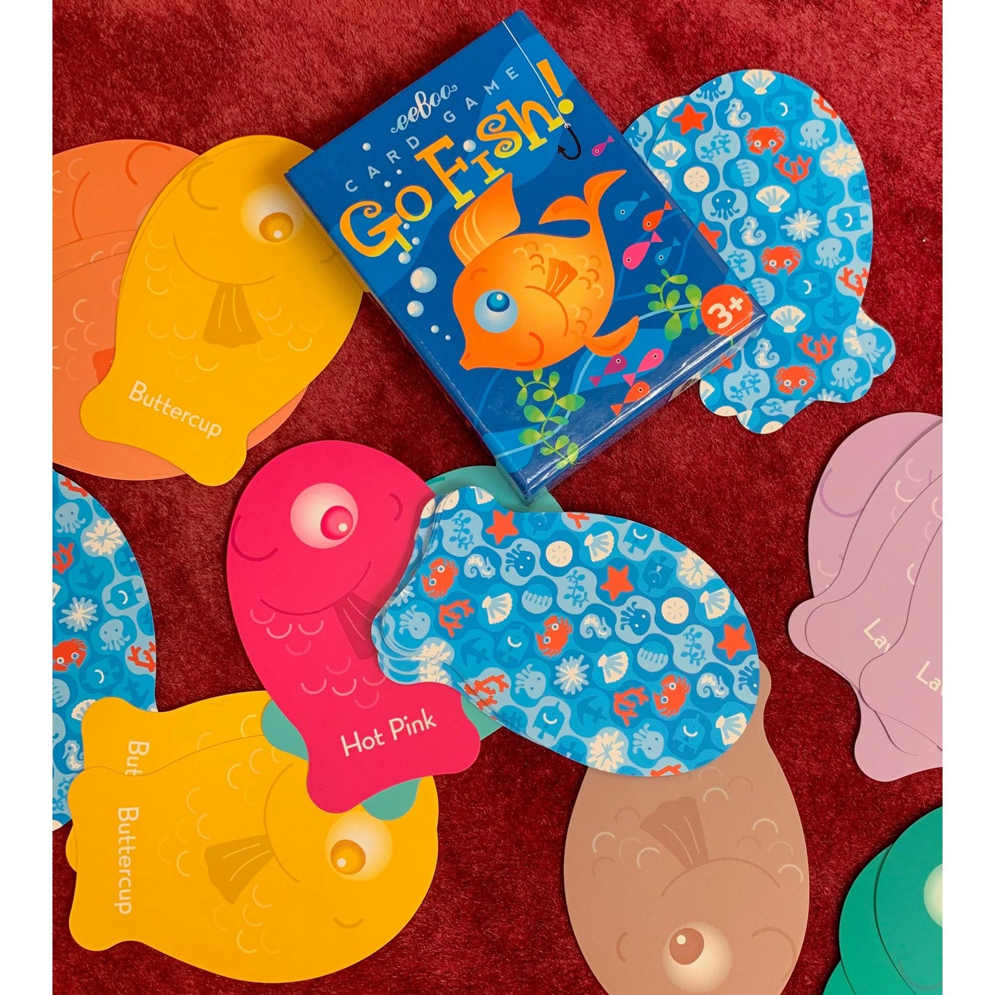 Colorful children's card game with fish-themed cards on a red background