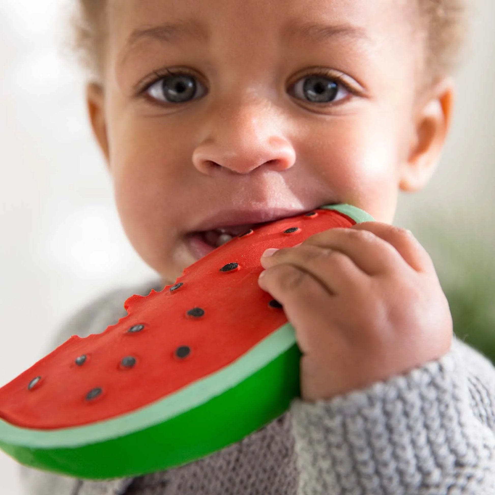 child holding watermelon teether