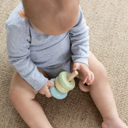 Baby playing with a colorful toy on a carpeted floor